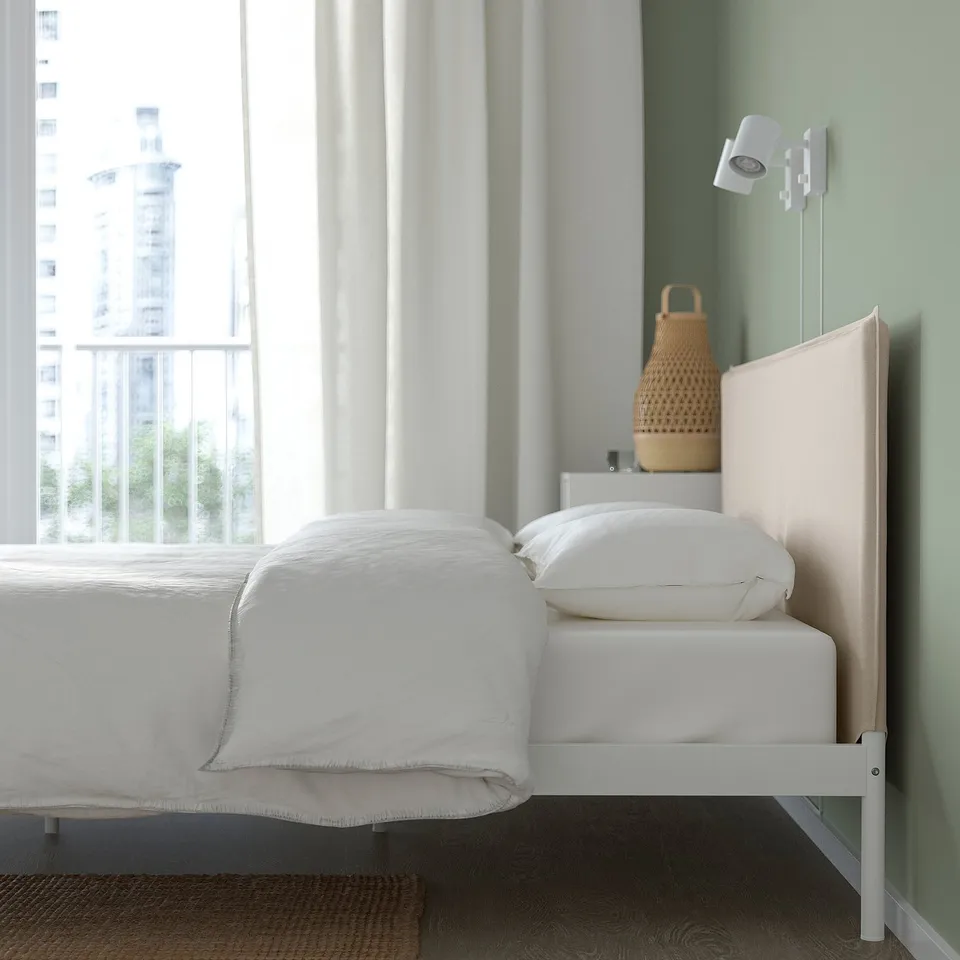 Modern bed with metal frame, padded headboard, and nightlights - cosy & practical.