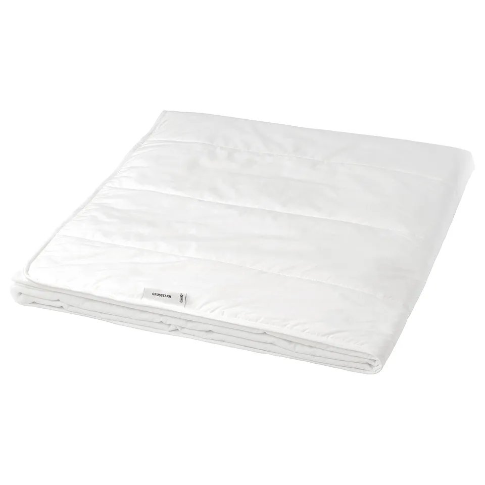 A white, folded comforter named GRUSSTARR, designed for cooling comfort with a printed dot fabric and 20% viscose filling.