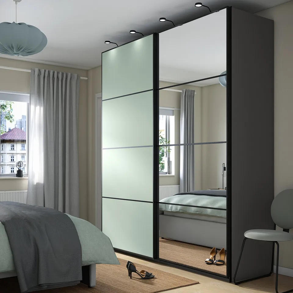 Modern bedroom with mirrored PAX wardrobe, bed, and window reflection.