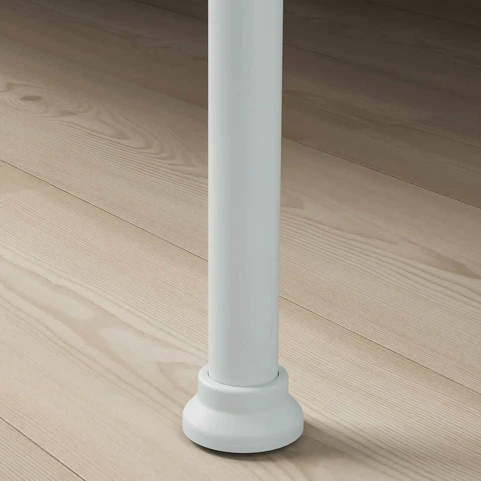 Close-up of modern white bed leg on wooden floor, showcasing clean design and sturdy build.