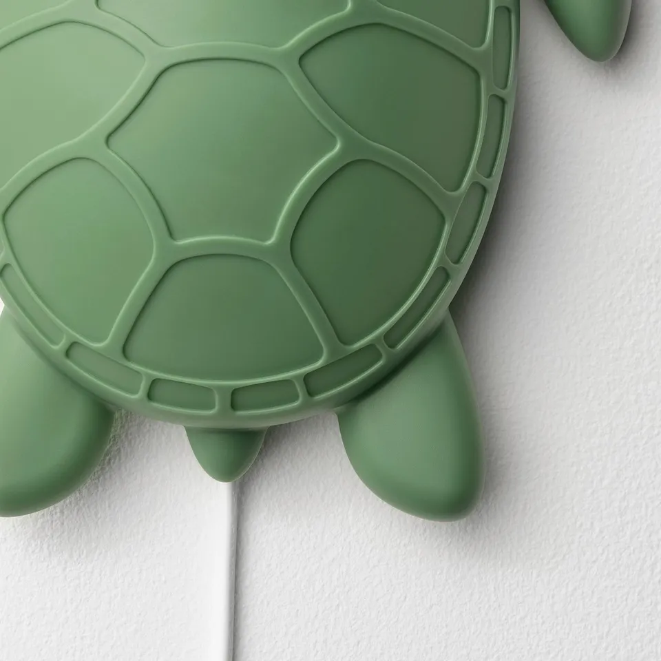 Bright green turtle wall lamp, part of blåvwingad collection, designed for kids with soft, safe light.