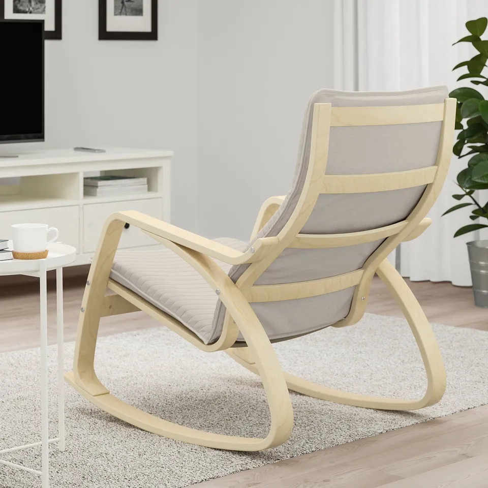 Light wooden rocking chair with grey cushion on a rug in a cosy room.