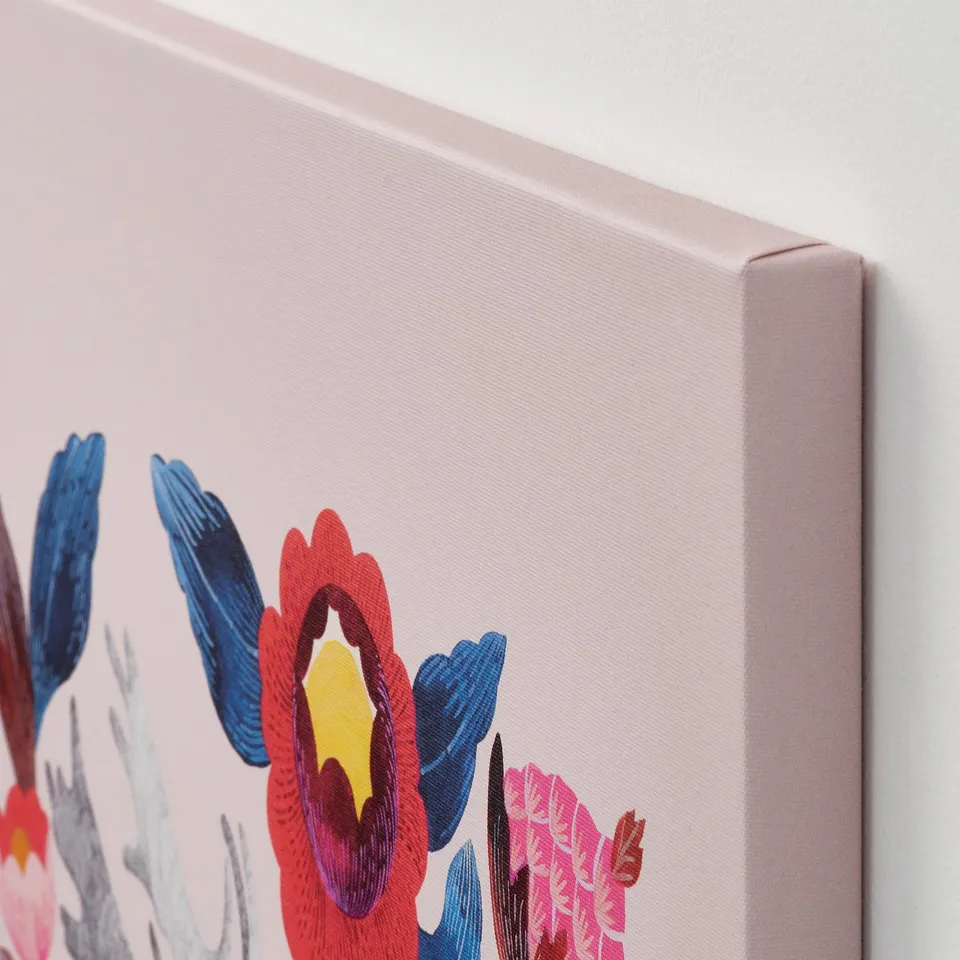 Close-up of canvas artwork on wall; vibrant flowers on pastel background, wrapped around deep frame.
