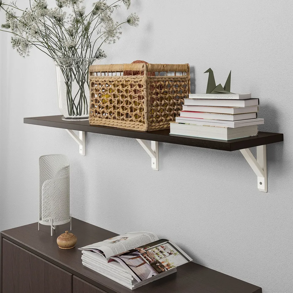 Wooden shelf with basket, books, and plant. Cabinet below with magazines and lamp, supported by metal brackets.