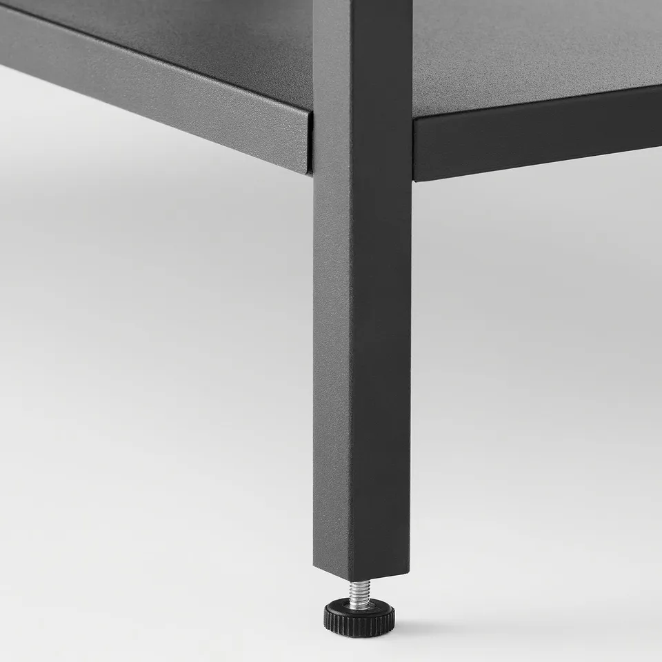 Black metal table leg with adjustable foot for stability.