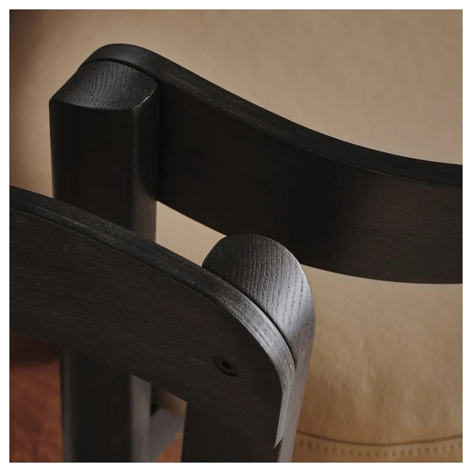A close-up of a high-quality chairs dark wood joint, showcasing fine craftsmanship and smooth finish.