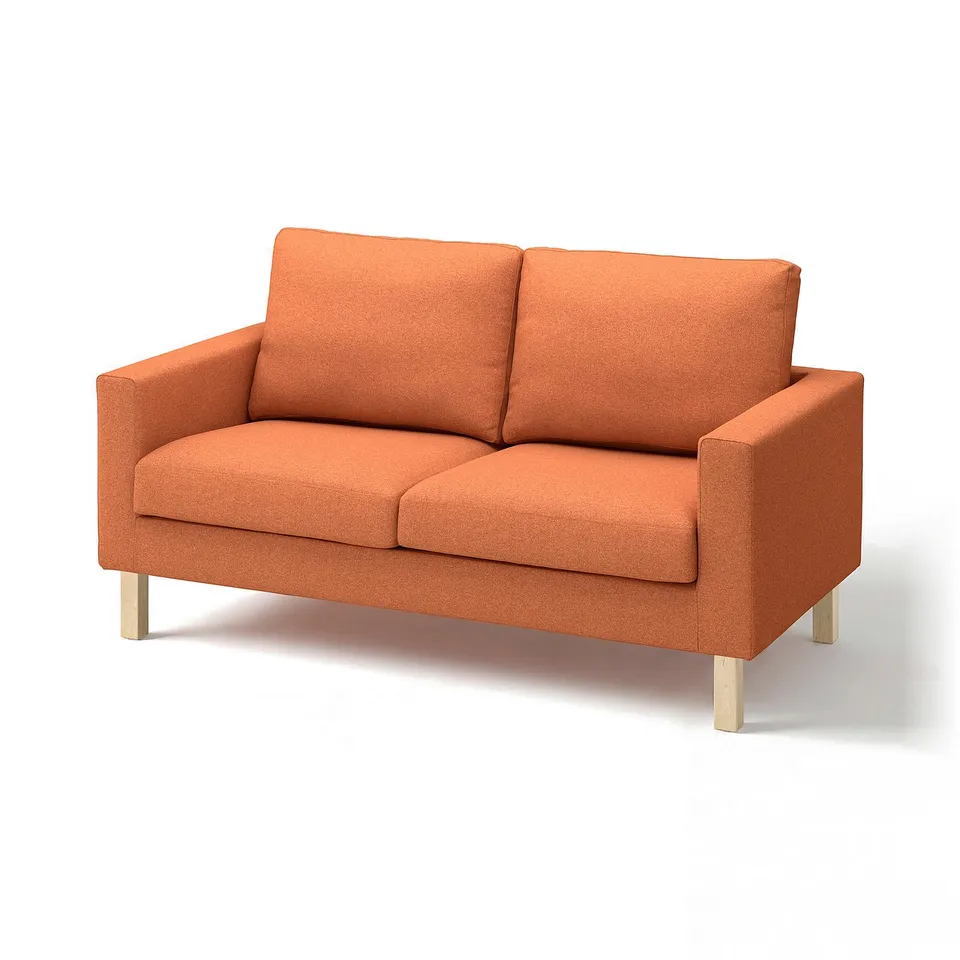 An orange SALTSJÖBADEN sofa with wooden legs, two cushions, and a boxy shape.