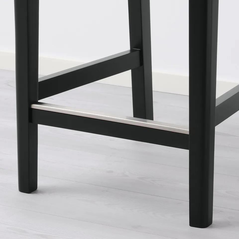 Modern black stool with sleek metal legs and sturdy base, designed for comfort and support.
