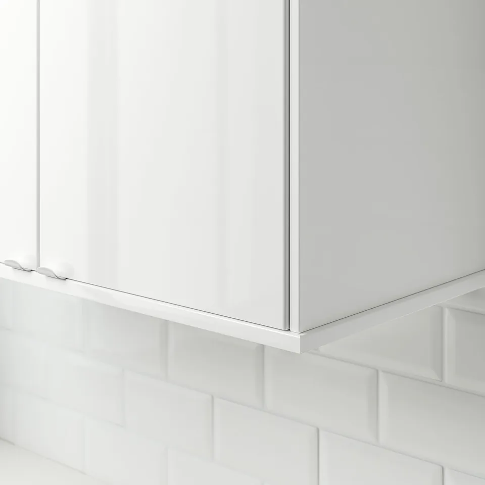 White glossy kitchen cabinet trim, hiding cables under a cabinet.