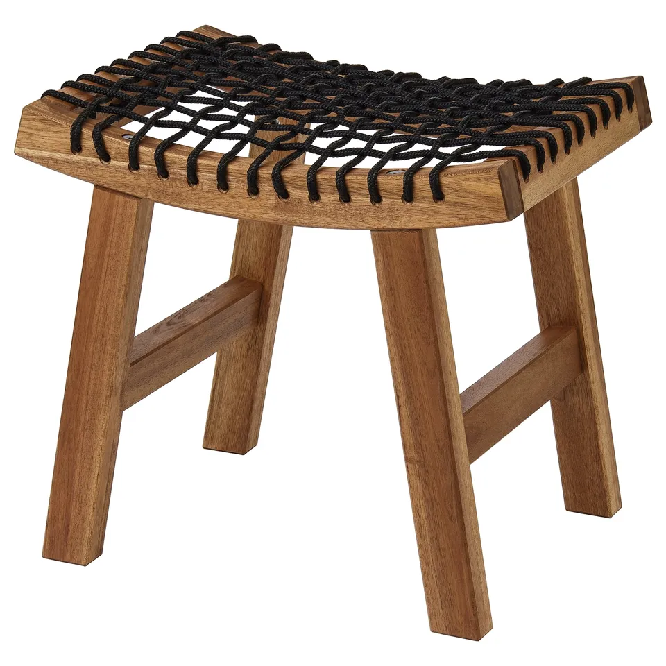 A STACKHOLMEN stool. Its brown, made of acacia wood with a woven black seat. It has a simple, triangular design with three legs.