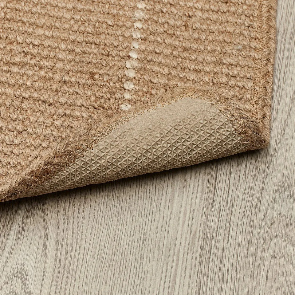 Natural jute door mat with textured backing, providing a stable grip indoors.