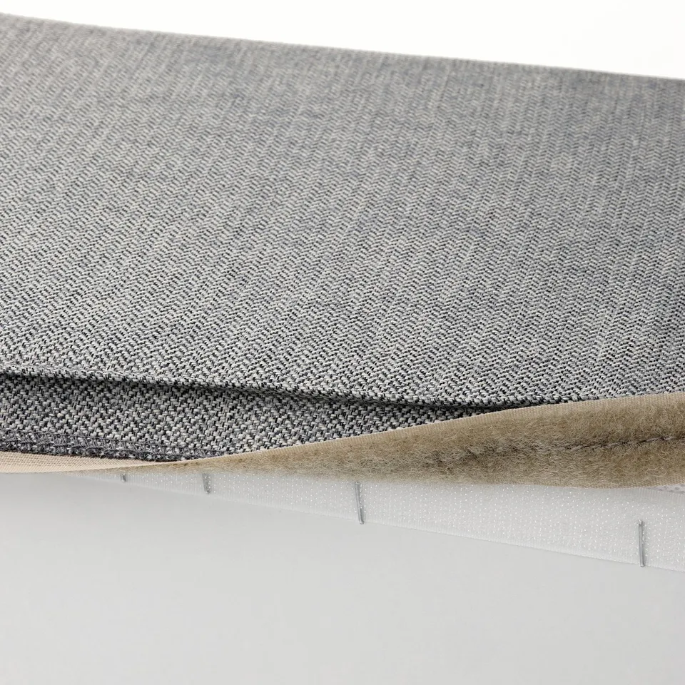 Close-up of KIVIK footstool cover in soft, durable fabric with herringbone pattern and visible stitching.