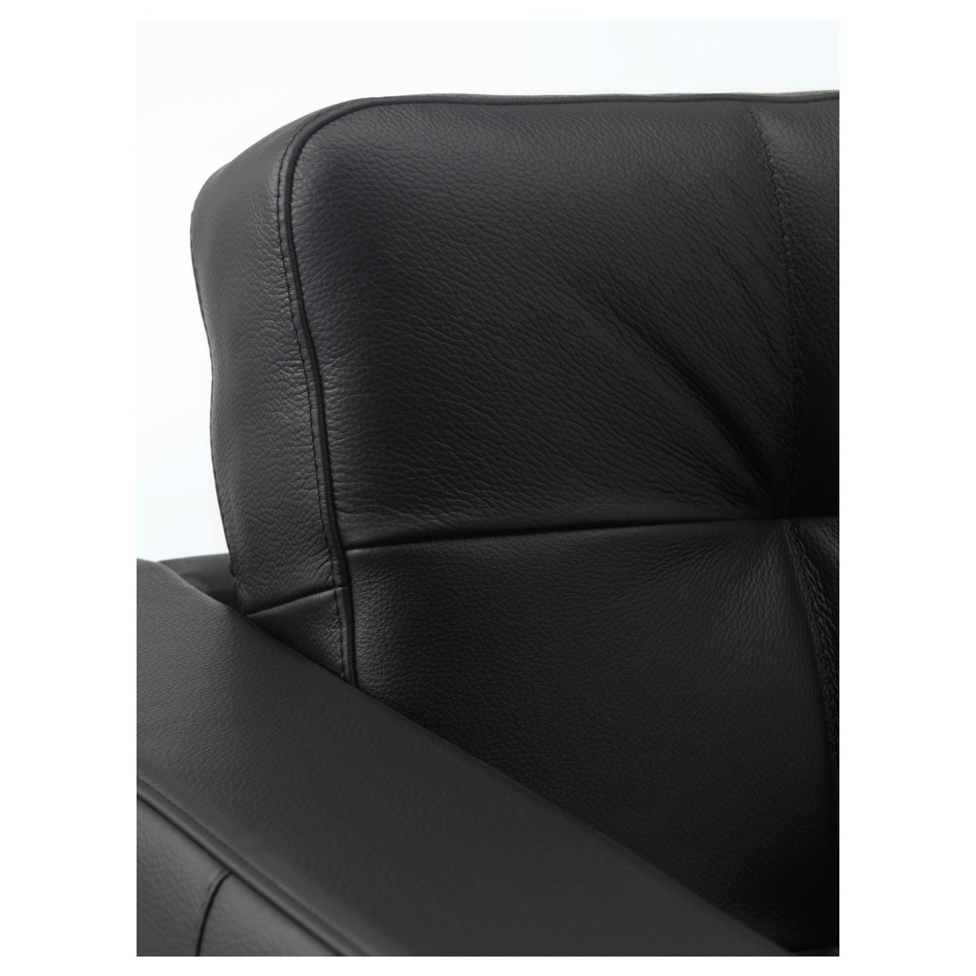 Black leather chair close-up: soft, textured grain, neat stitching, padded seat and back, suggesting comfort and durability.