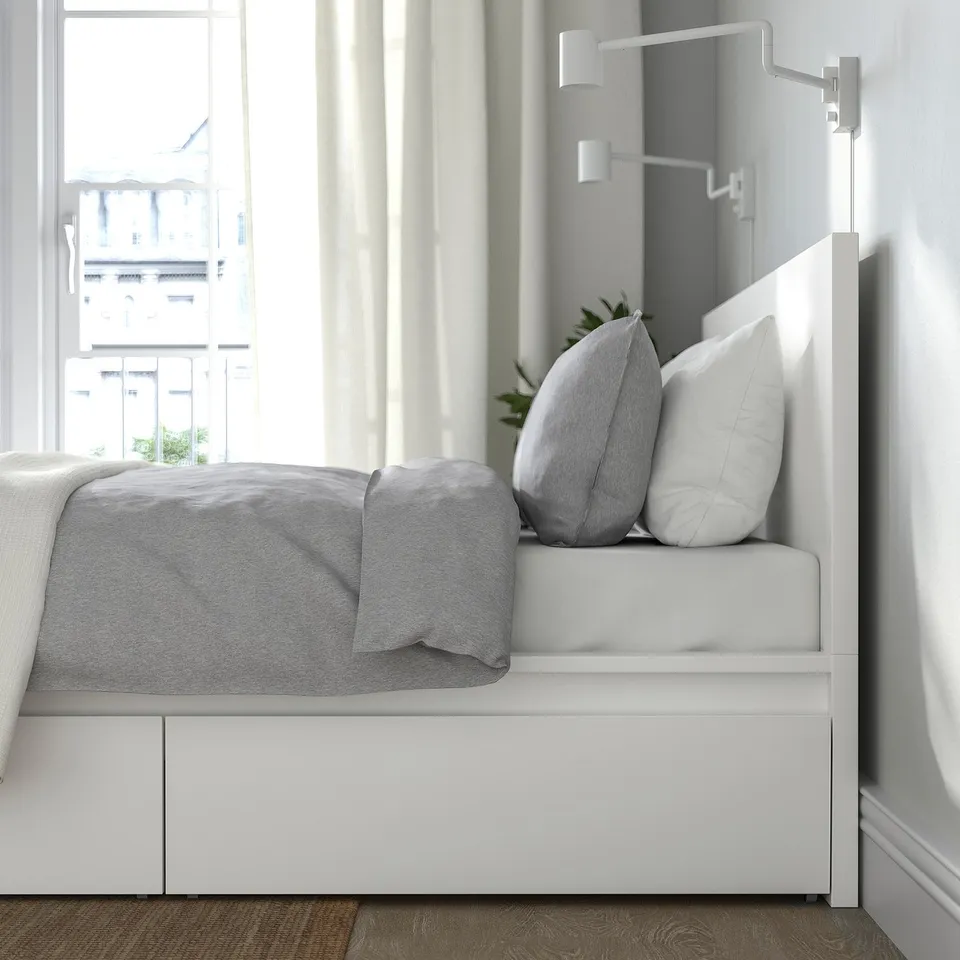 Minimalist bed with storage drawers, adjustable sides, and high headboard for seating.