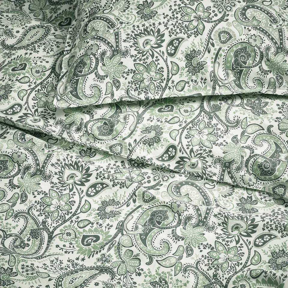 Green paisley print bedding, finely detailed with intricate patterns, folded neatly, showcasing high-quality fabric and design.