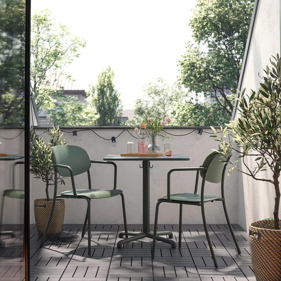 Green VISINGSÖ chairs fit under balcony table, creating cosy outdoor seating.