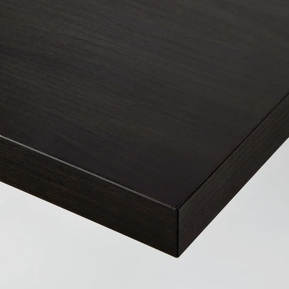 Close-up of sleek, black table top with smooth finish and square edge.