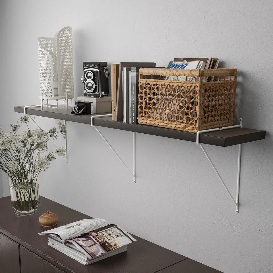 Wall shelf with books, camera, basket, and vase on brackets. Character count: 55