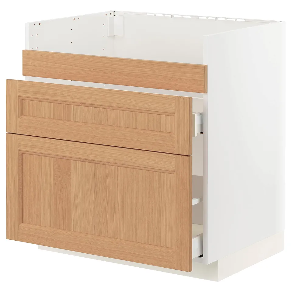 An ikea METOD kitchen cabinet with oak drawer fronts. It has a white base and three wooden drawers.