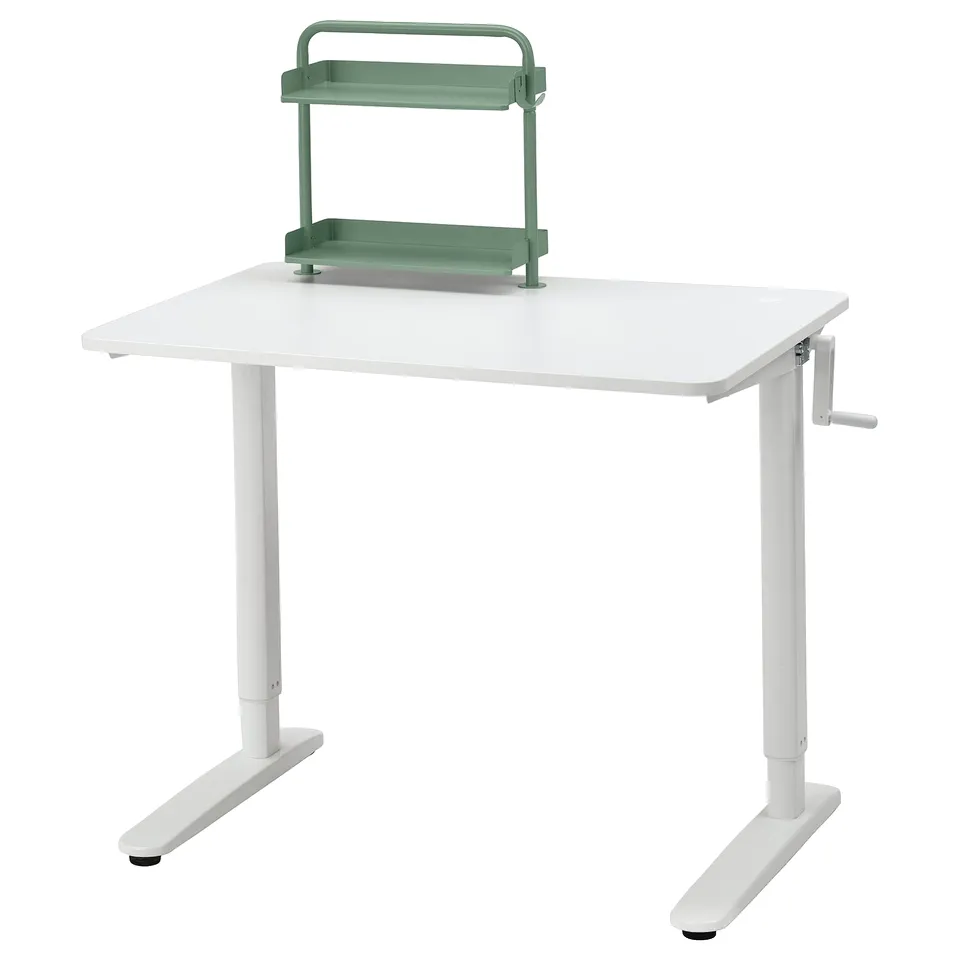 A white RELATERA adjustable desk with a green shelf. The crank handle allows height adjustment for sitting or standing.