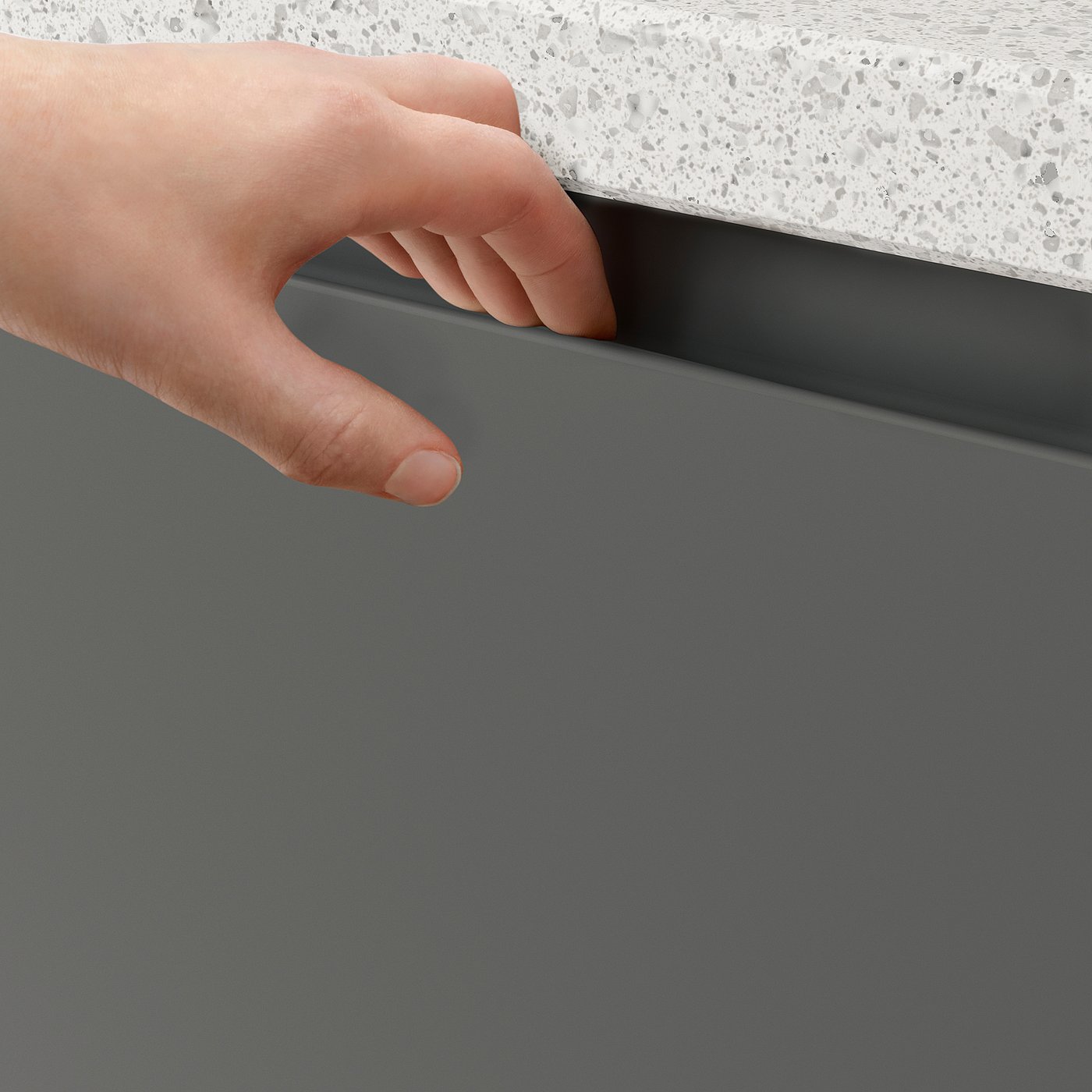 Hand pulls dark grey VOXTORP cabinet with integrated handle. Modern, minimalist design.