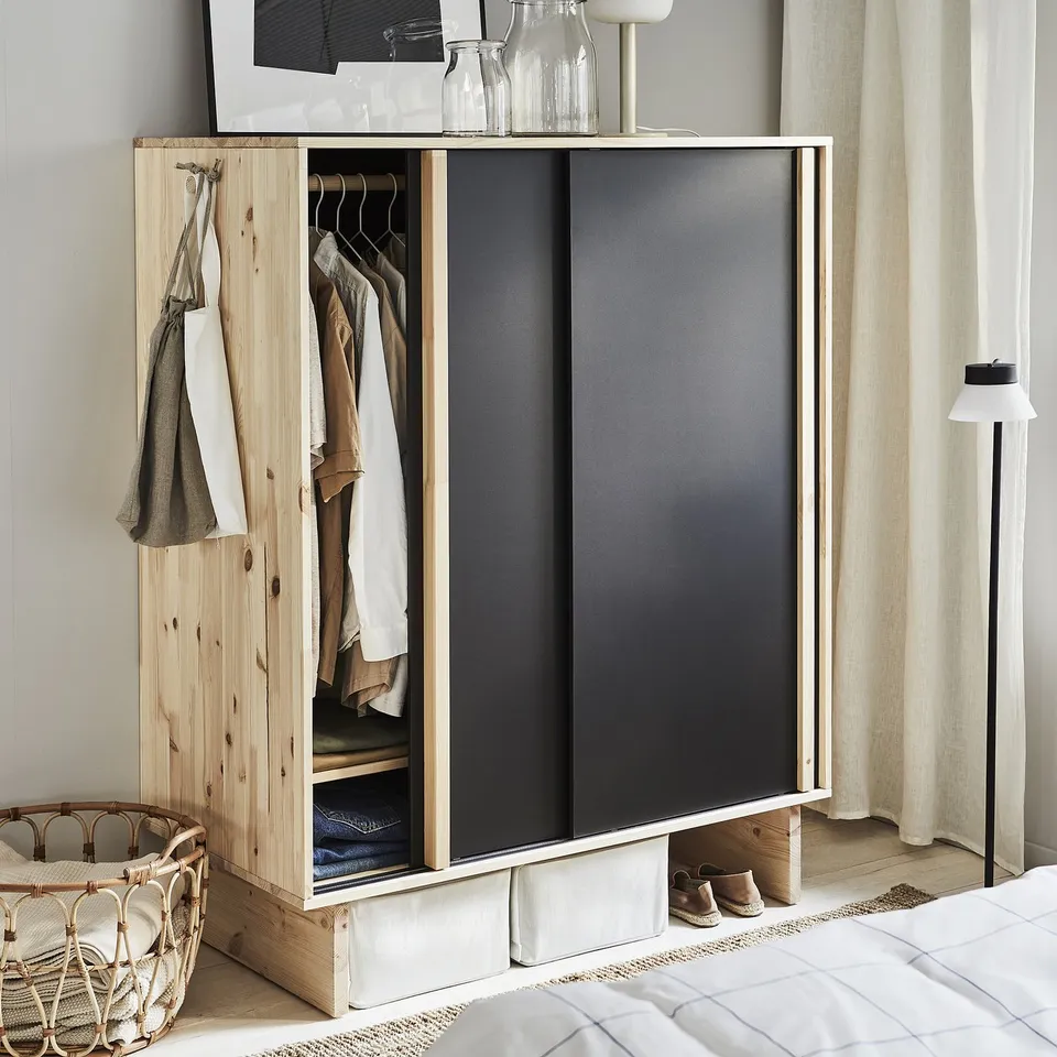 Modern bedroom with light wood and black wardrobe, minimalist design.