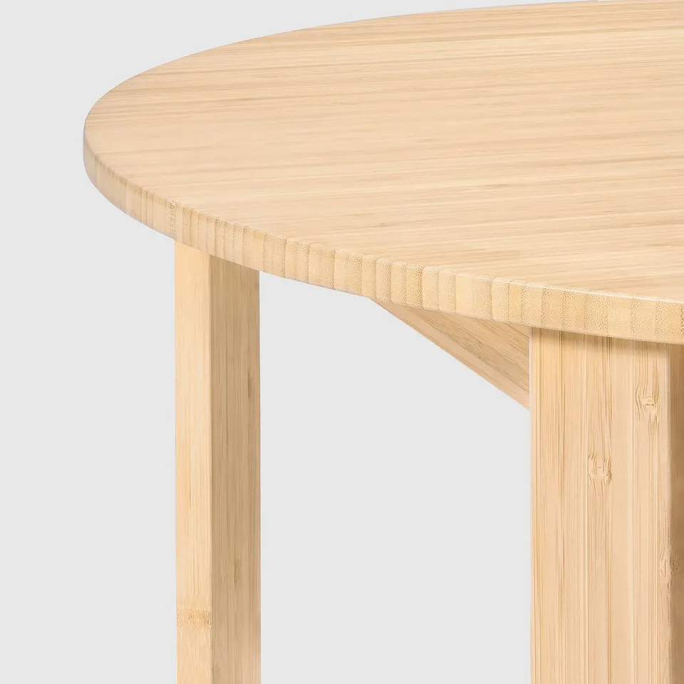 Round bamboo coffee table with smooth, light-colored surface and folded legs for easy storage.
