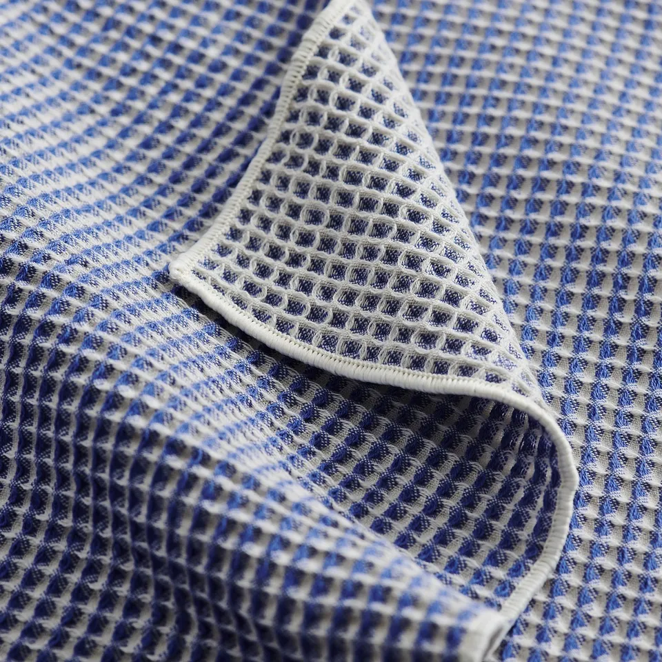 Folded blue and white waffle texture towels, thick cotton, high absorbency, elegant style.