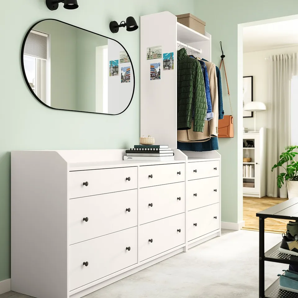 Modern bedroom with HAUGA dressers, wardrobe, mirror, and light green walls.