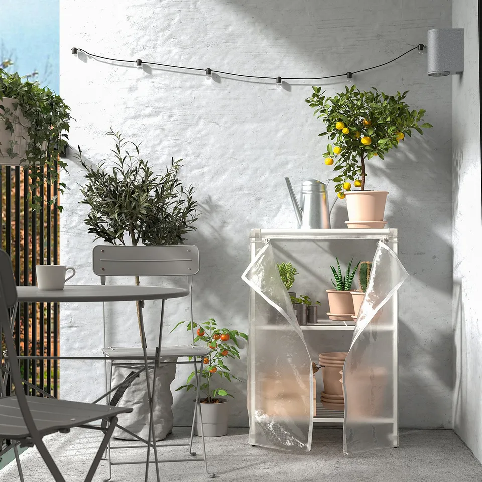 JOSTEIN grey metal storage with white cover, suitable for outdoors. Holds plants, fits balcony. Compact yet spacious.