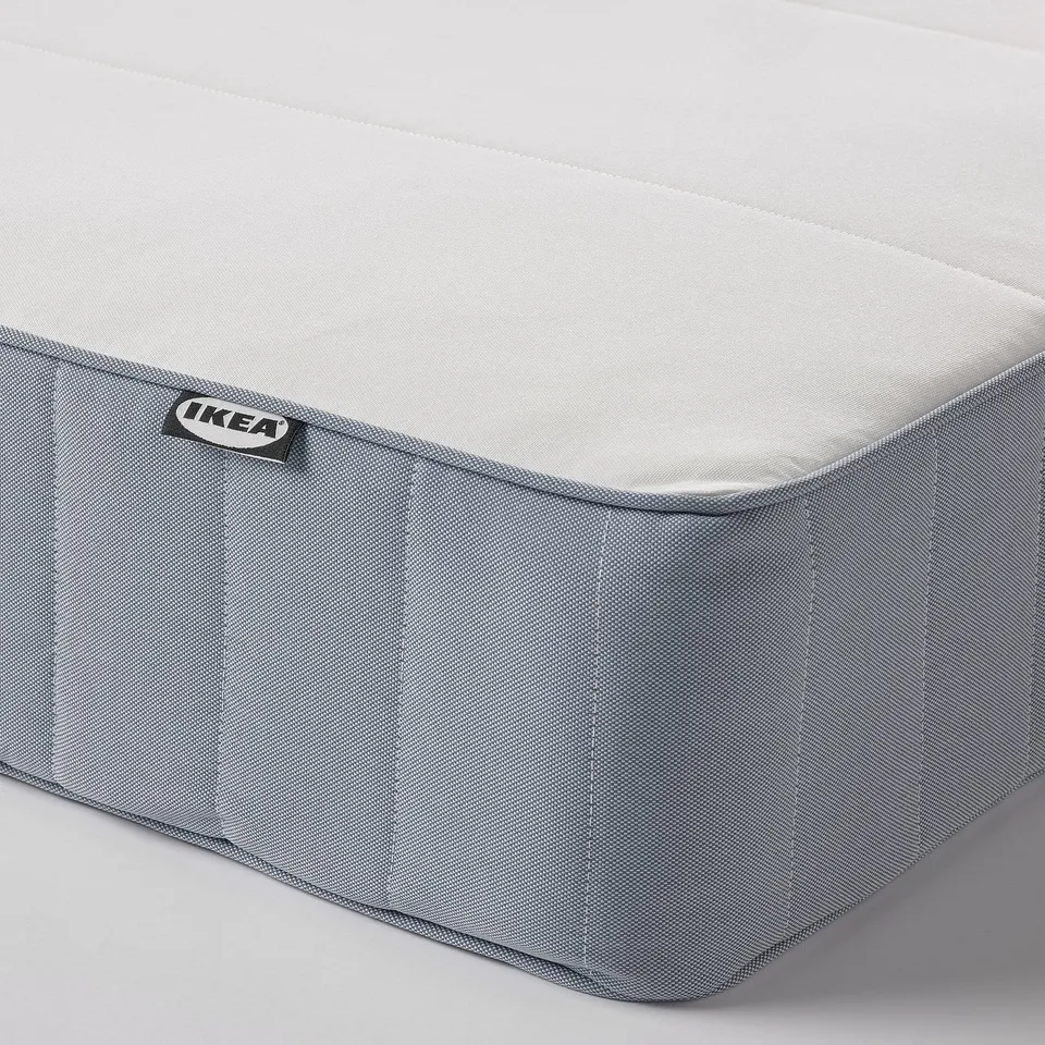 Mattress close-up: firm, textured grey fabric with ikea tag.