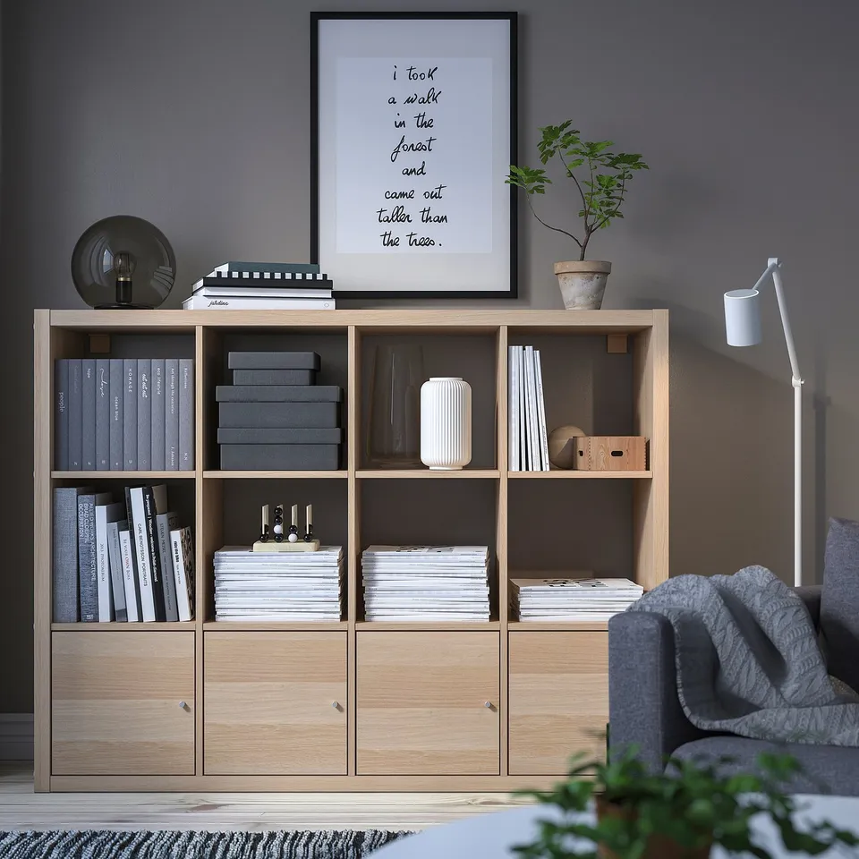 Modern living room with KALLAX shelves, sofa, and lamp.