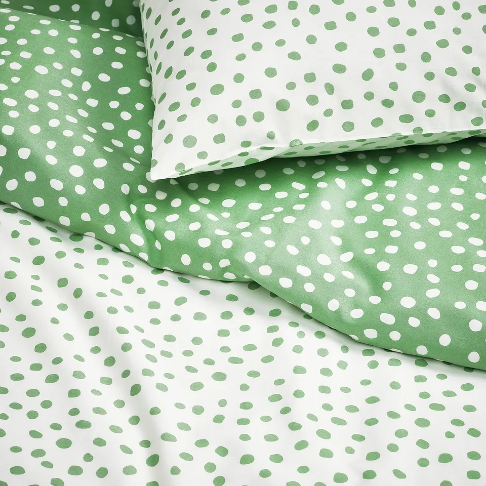 Green and white polka dot duvet set with soft, breathable fabric, neatly folded.