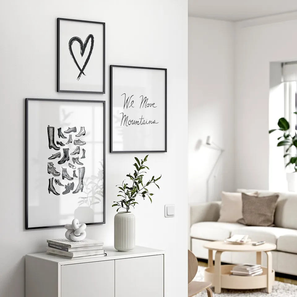 Three black-and-white wall posters: heart, boots, quote. Couch, coffee table, plant.