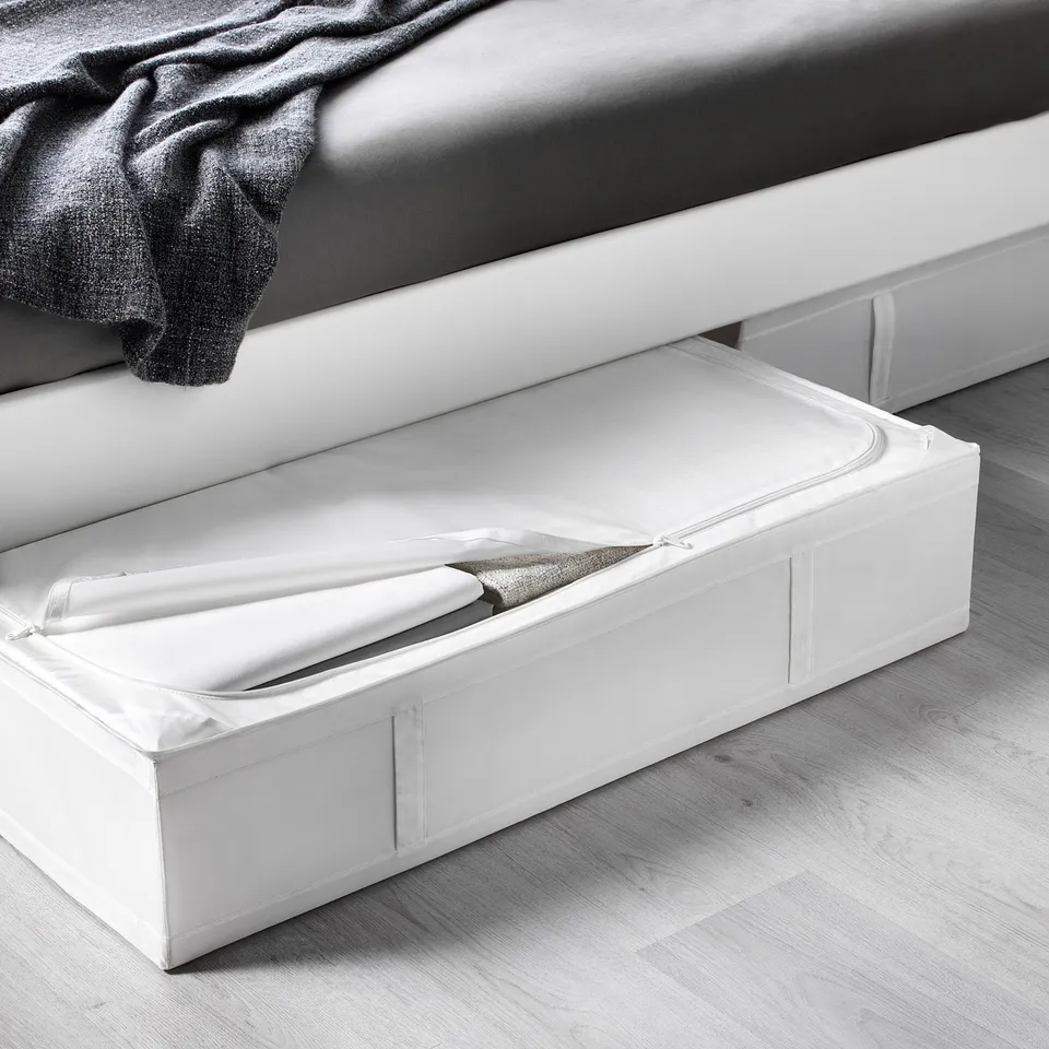 White storage case under bed, open showing folded blankets; ideal for seasonal items.