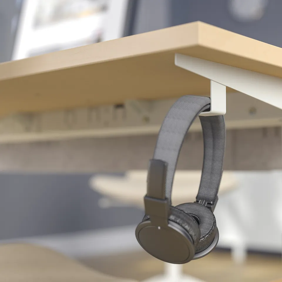 Hooks on desk frame hold headphones or bags, keeping workspace organised.