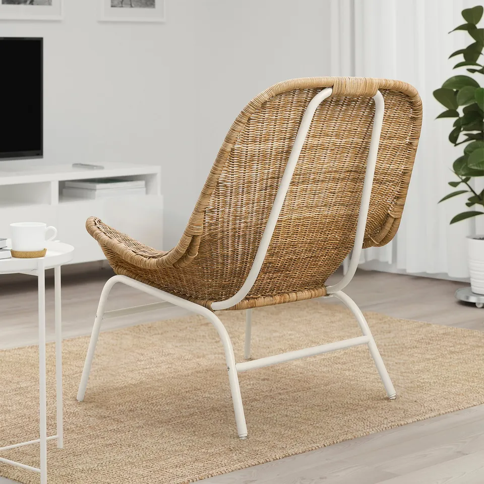 Wicker-style lounge chair with modern curves. Neutral beige tone, light & sturdy. Large, comfortable design for trendy living spaces.