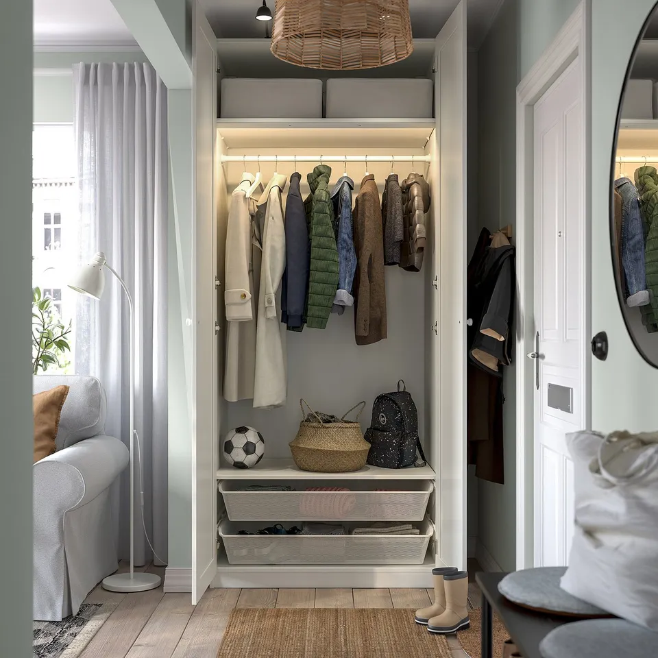 Modern closet with hangers, shelves, and baskets, well-lit and organised with various accessories.