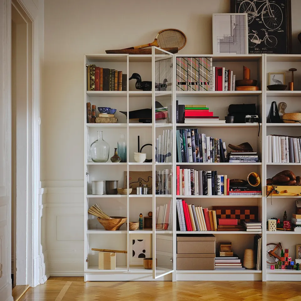 Bookshelf with colourful books and decor, topped with posters.