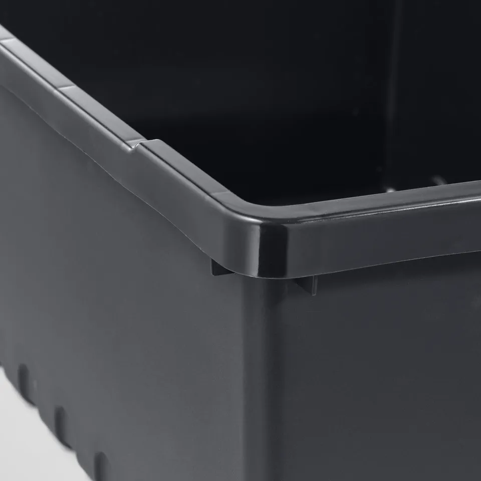 Black container with reinforced rim and legs.