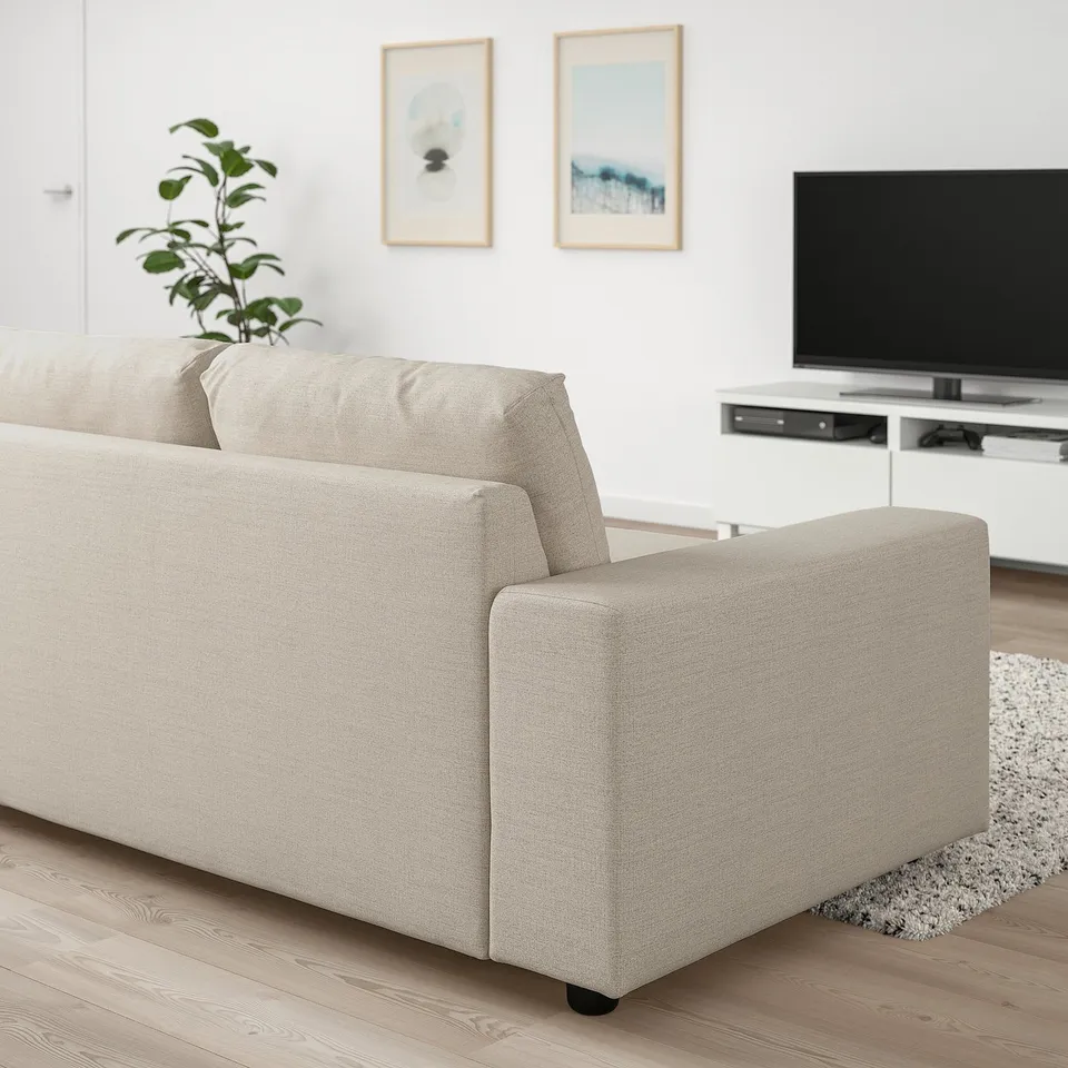 Beige VIMLE sofa with chaise in modern living room, transforms into bed, minimalist decor with tv stand and art.