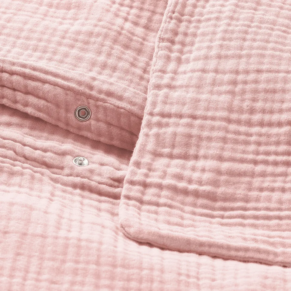 Pink duvet cover with soft, wavy texture; metal press-stud closure visible.