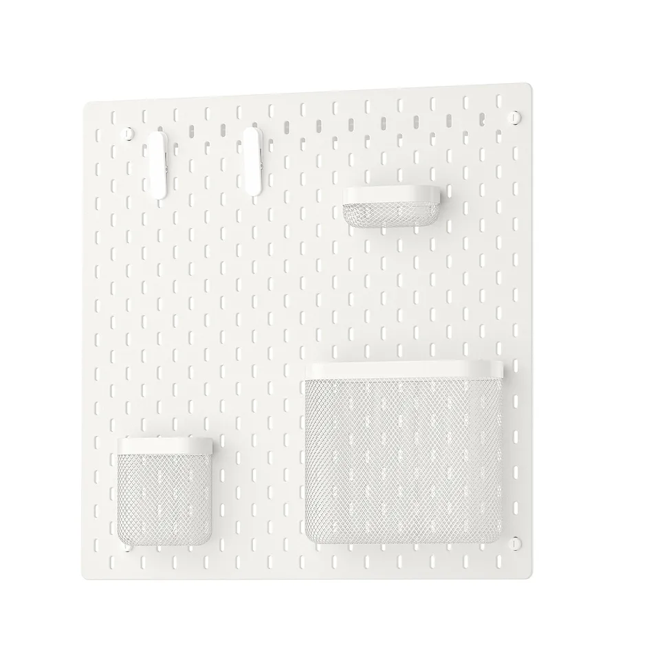 White SKÅDIS pegboard with mesh baskets and hooks for wall organisation.