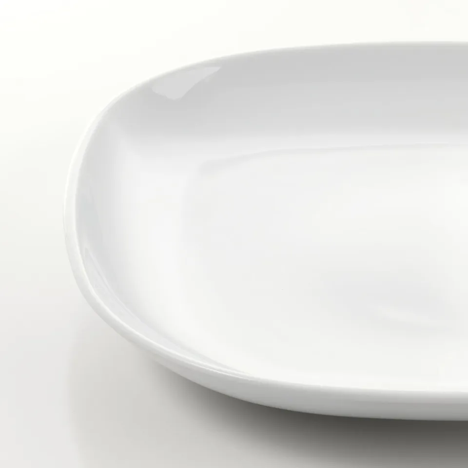 White porcelain plate with smooth, glossy finish. Rounded edges, pristine condition.
