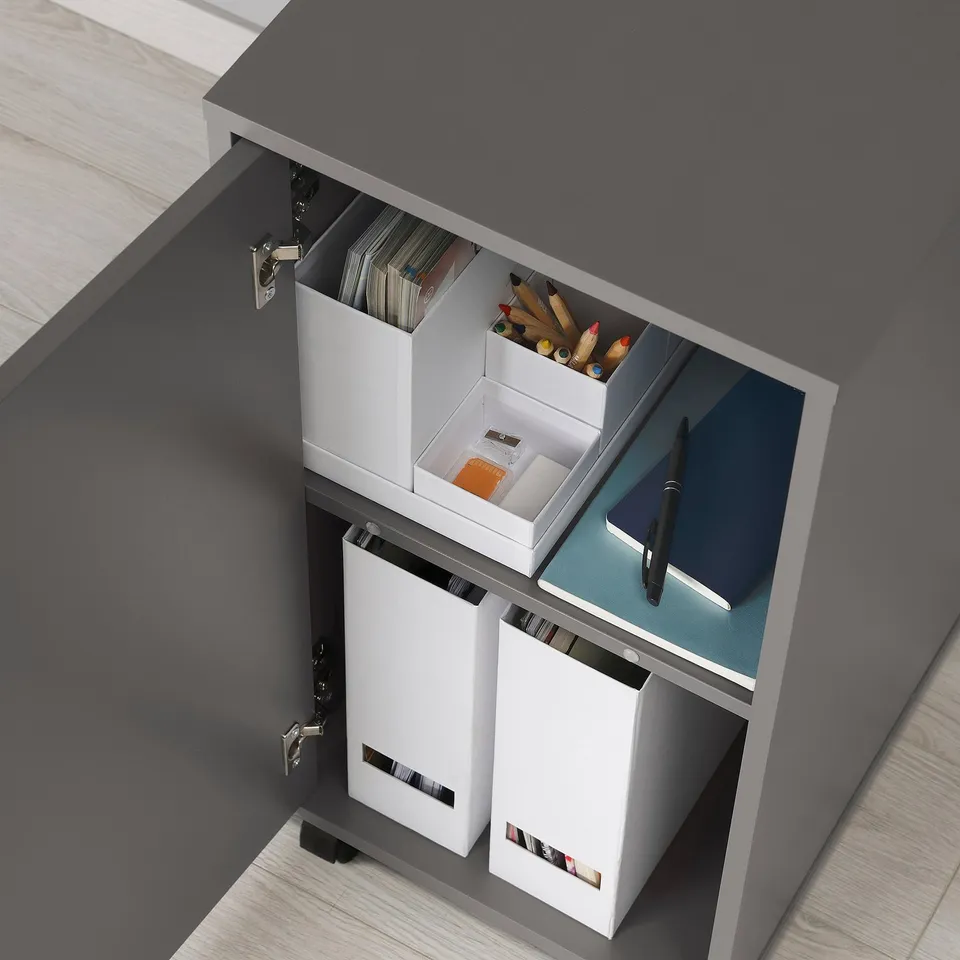 Cabinet with sliding shelves and castors, one shelf holds coloured pencils, another has a clipboard.
