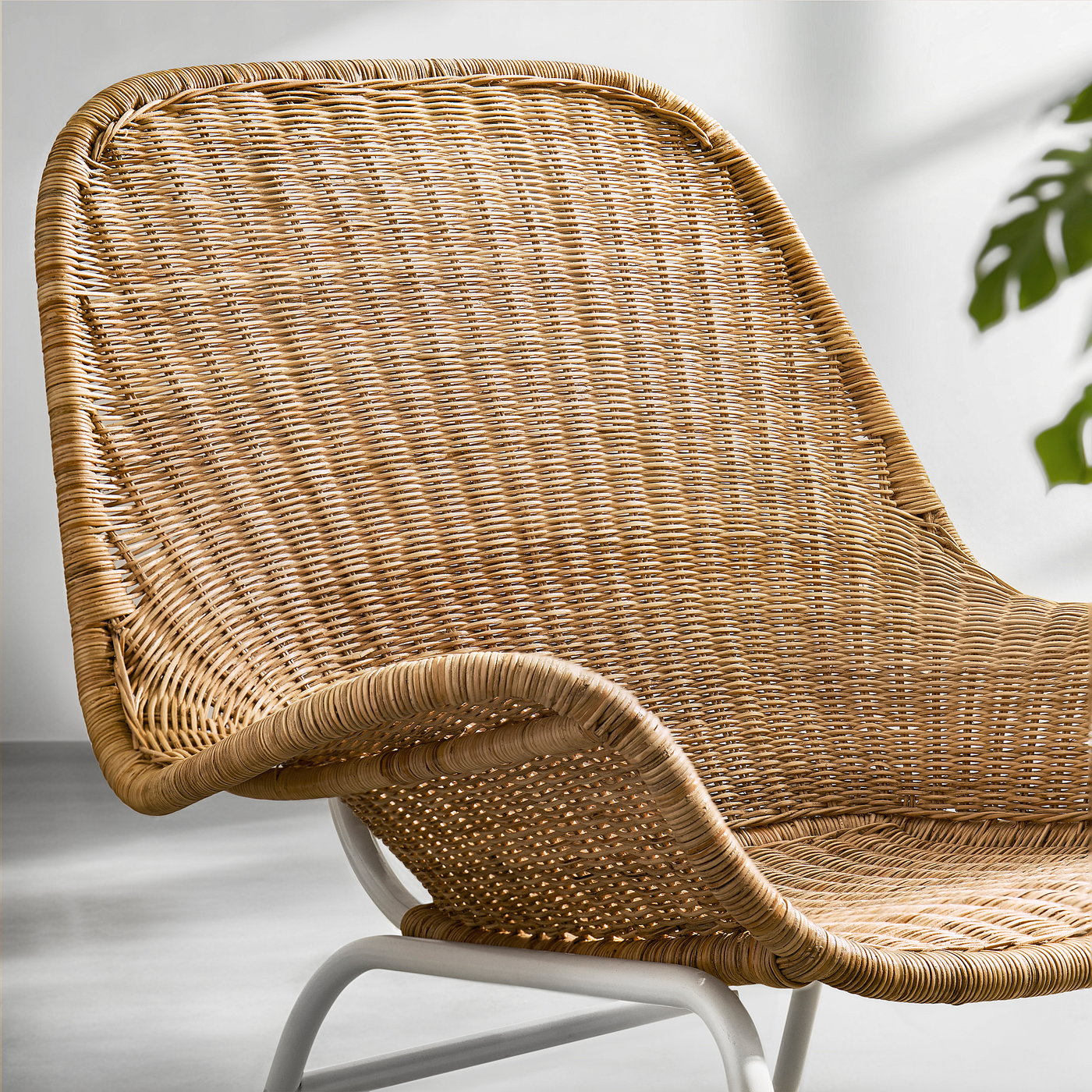 Wicker chair close-up, showing handwoven rattan seat, armrests, and backrest. Natural material, durable, and lightweight.