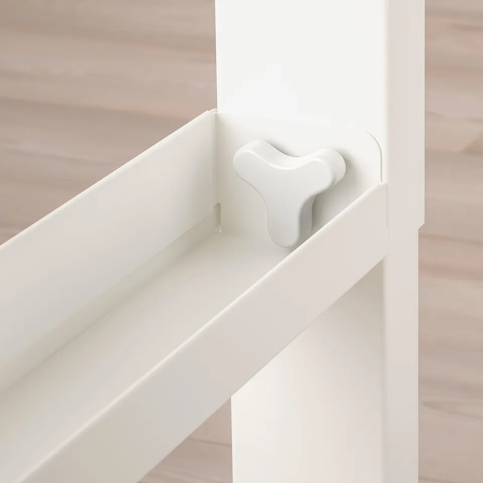 White desk with adjustable height mechanism on wooden floor.