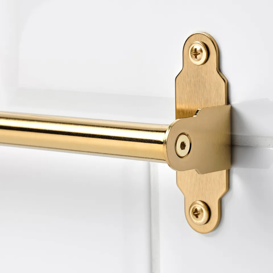 Golden metal rail mounted on white wall with secure, minimalistic attachment, ideal for kitchen accessories.