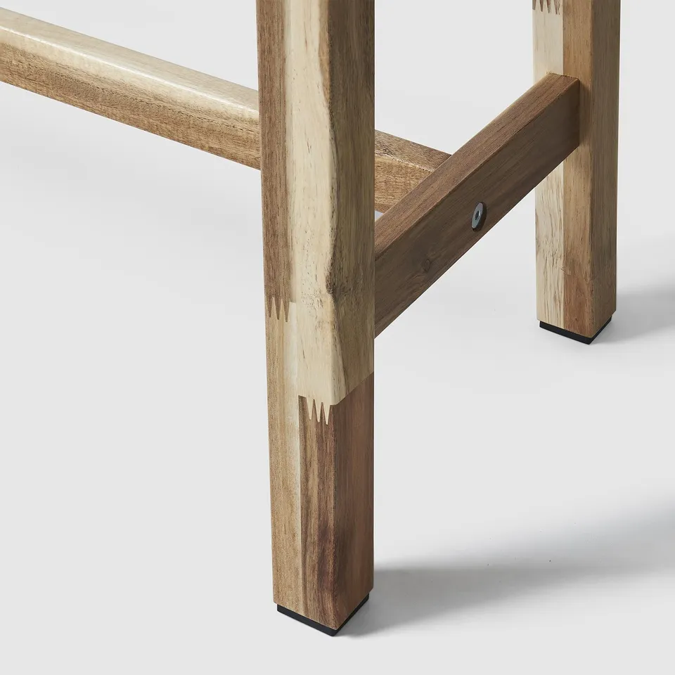 Close-up of sturdy acacia wood bench legs, joined with mortise and tenon joints, finished with clear lacquer.