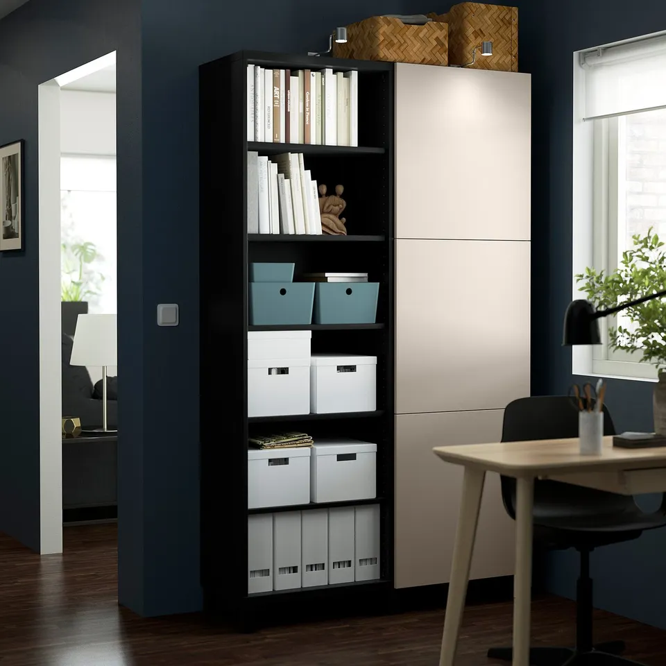 Modern home office with BESTÅ storage, books, and a desk with chair and lamp.